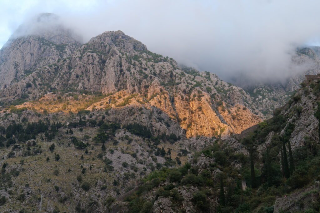 The majestic mountains towering behind old town Kotor are a must-see during your Montenegro day trip from Dubrovnik!