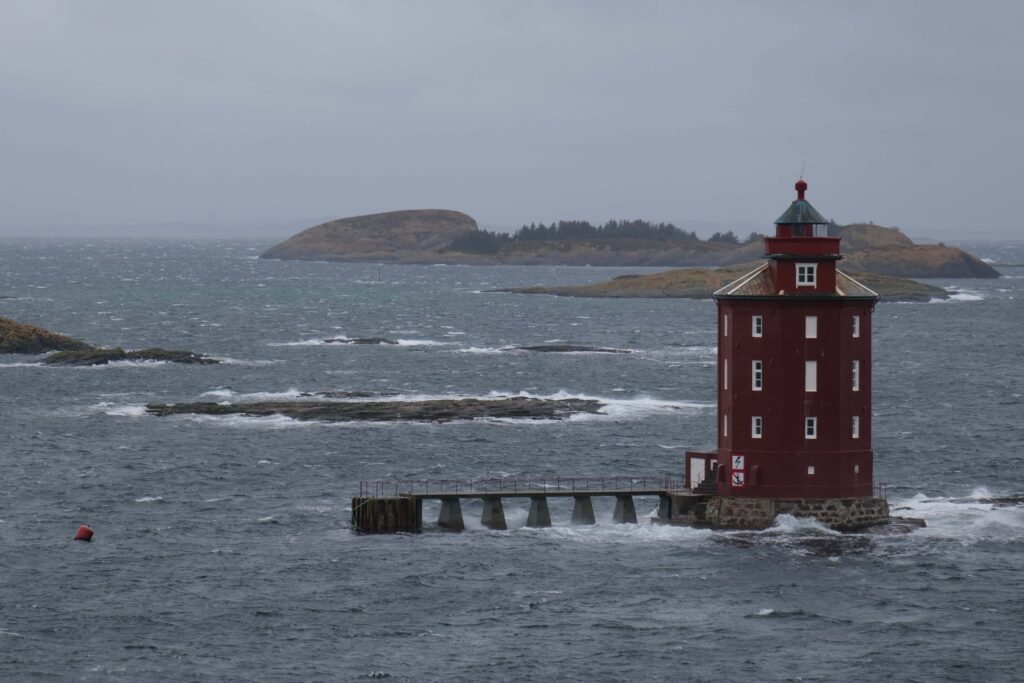 Red lighthouse amidst stormy seas. The incredibly remote Kjeungskjaer Lighthouse.