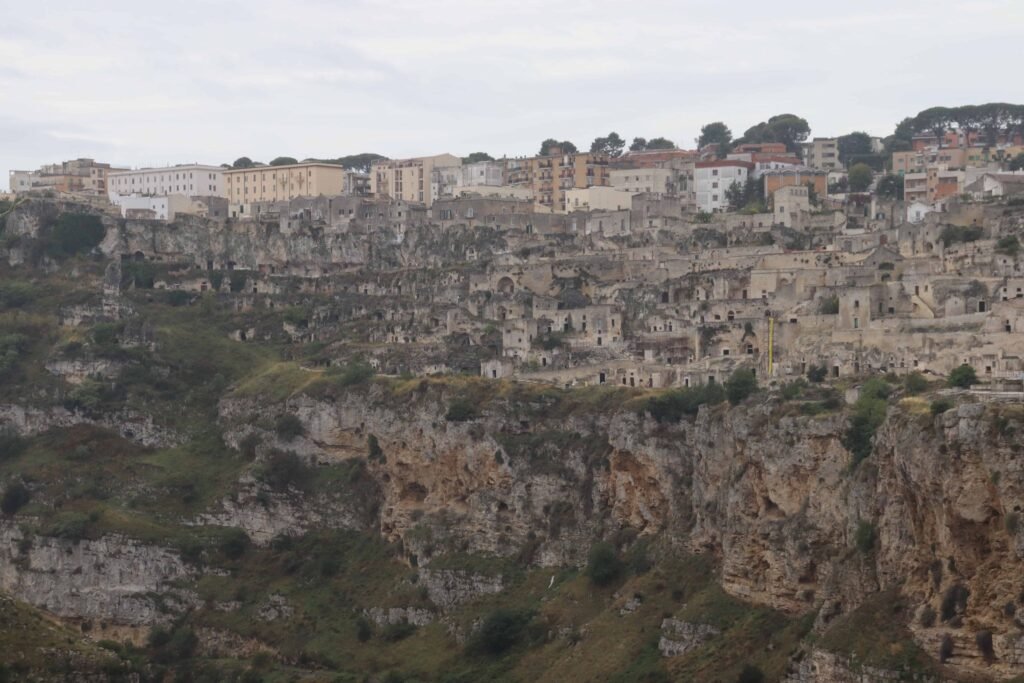 Historic cave dwellings on rocky hillside.
